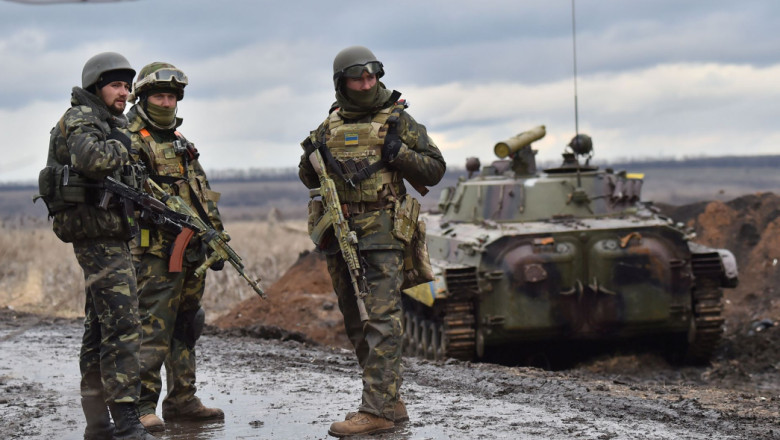 Militari ucraineni lângă un vehicul blindat.