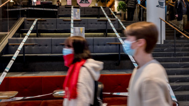 doi oameni trec prin fata unui restaurant inchis in suedia din cauza masurilor anticoronavirus