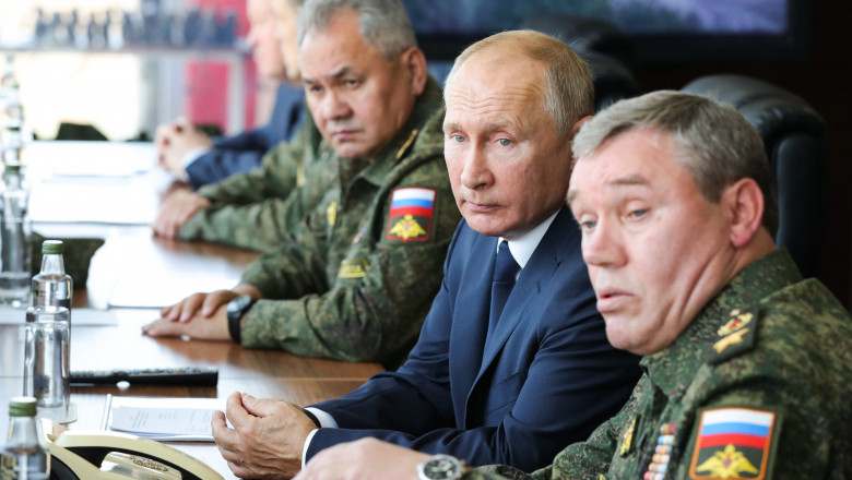 Ministrul rus al Apărării, Serghei Șoigu (s), președintele rus, Vladimir Putin (centru) și șeful Statului Major al armatei ruse, asistă la un exercițiu militar