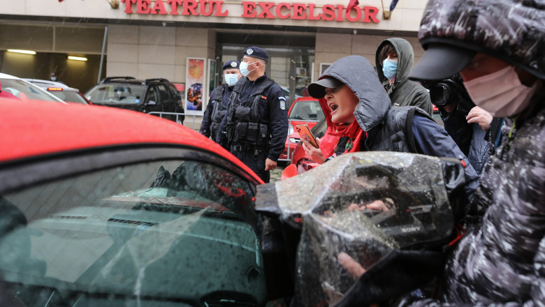 protestatari care striga in ploaie in timp ce andreea moldovan se urca in masina