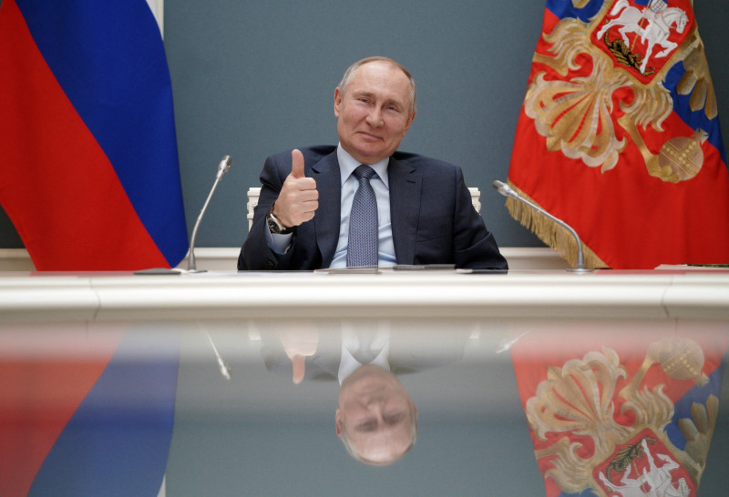 Vladimir Putin face semnul OK în timp ce stă la biroul prezidențial