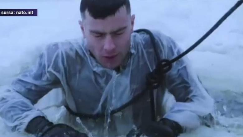 un militar iese la suprafața apei printr-o copca taiata in gheata
