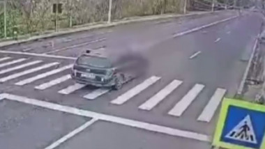 Momentul în care o mașină lovește o femeie pe trecerea de pietoni.