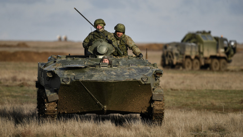 trei soldati rusi intr-un tanc pe un camp