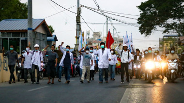 Un grup de oameni protestează pe o stradă din Myanmar.