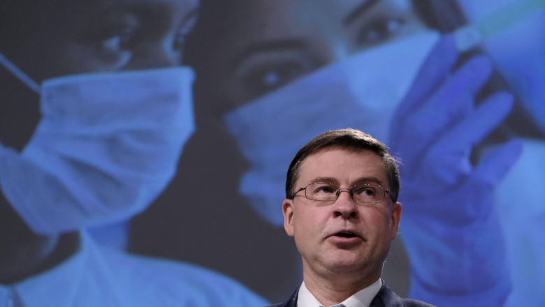 Valdis Dombrovskis, vicepreşedinte executiv responsabil cu comerţul, face o declaratie de presa in spatele unei fotografii cu cadre medicale cu masti de protectie