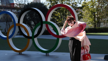 O femeie din Japonia trece pe lângă simbolul Jocurilor Olimpice.