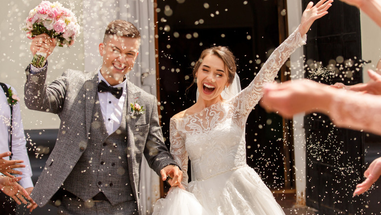 tineri casatoriti trec fericiti printr-o ploaie de confetti