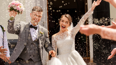 tineri casatoriti trec fericiti printr-o ploaie de confetti