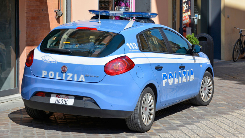 Mașină a poliției italiene parcată lângă o clădire.