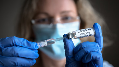 cadru medicat care extrage cu seringa vaccinul dintr-o doza