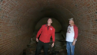 doi barbati intr-un tunel din caramida