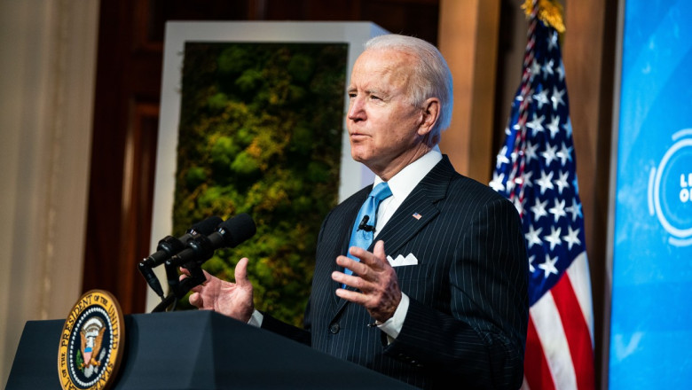 Joe Biden gesticulează cu mâinile de la pupitrul prezidențial