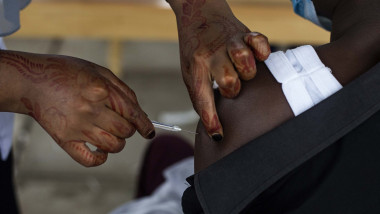 asistenta cu tatuaj ope mana vaccineaza un pacient in africa