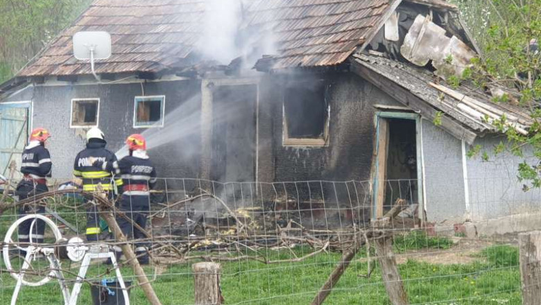 pompieri care incearca sa stinga un incendiu la o casa