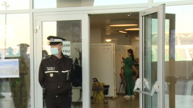 un politist sta in fata centrului de vaccinare de pe stadionull oblemenco din craiova