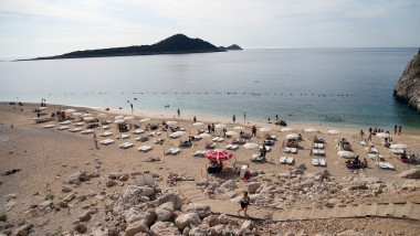 turisti si sezlonguri pe o plaja din antalya