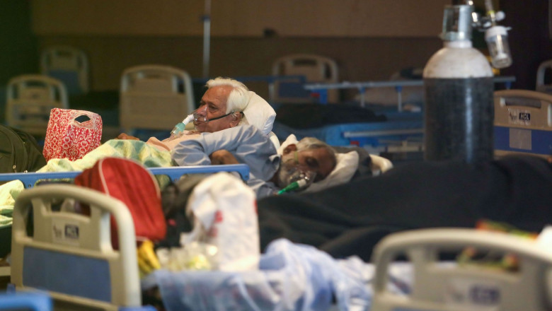 bolnavi de Covid cu măști de oxigen, întinși pe paturi, într-un spital