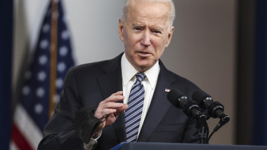 Joe Biden, la pupitru, gesticulează cu mâna dreaptă