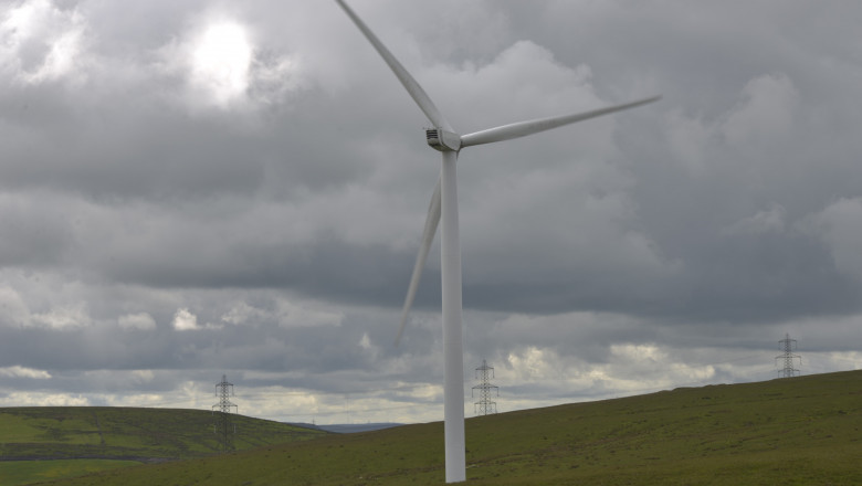 Imagine cu o turbină eoliană pe un câmp.