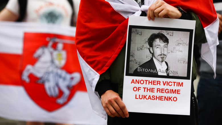 un om care tine in mana o fotografie cu activistul Vitold Așurak la un protest in polonia