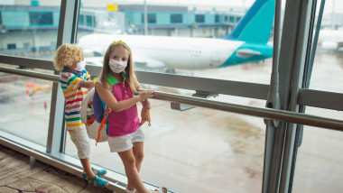 copii cu masti in aeroport se uita la avioane