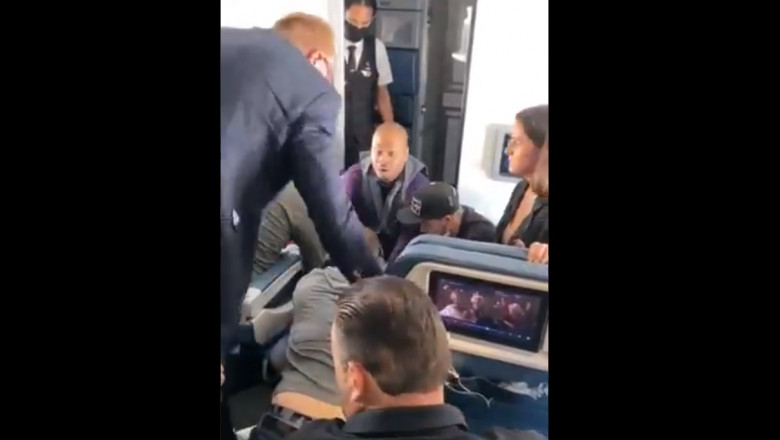 un barbat este imobilizat de pasageri dupa ce a iincercat sa intre în cabina pilotilor unui avion