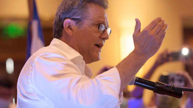 arturo cruz din profil cu camasa alba si ochelari gestioneaza in timpul unui discurs