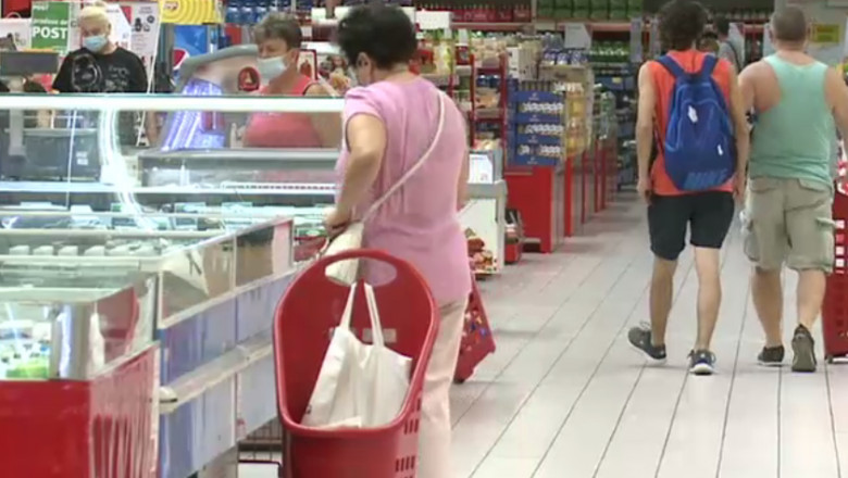 Oameni la cumpărături într-un supermarket.