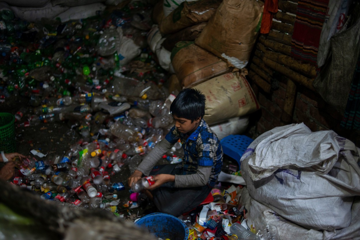 Copil din Bangladesh care lucreză la o fabrică de reciclare a plasticului.