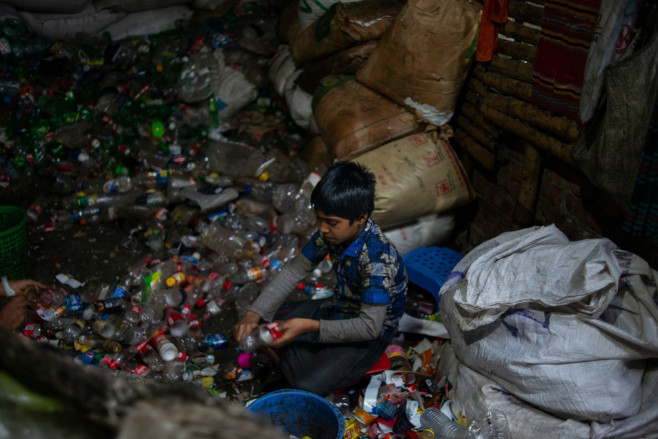 Copil din Bangladesh care lucreză la o fabrică de reciclare a plasticului.