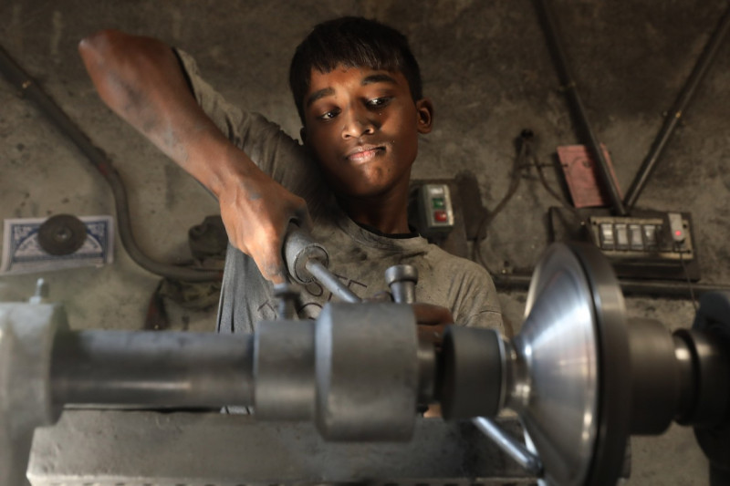Băiat de 14 ani, în timp ce confecționează un obiect din aluminu.