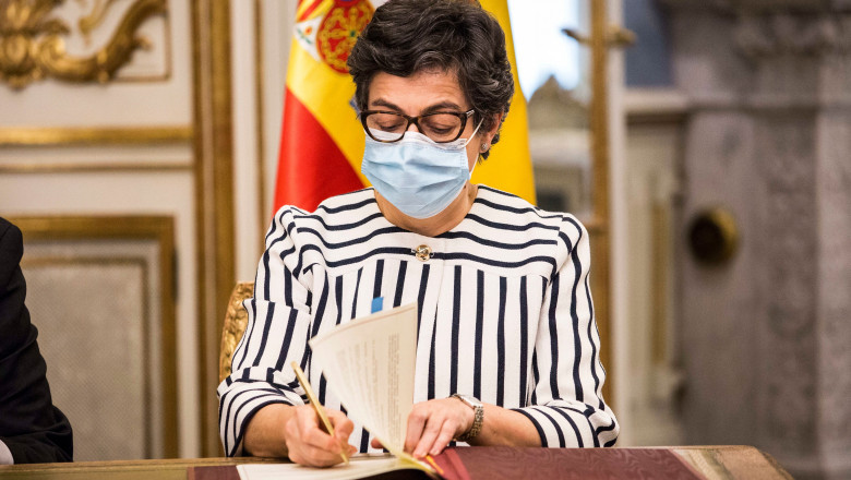 Ministrul de externe al Spaniei, Arancha Gonzalez Laya, cu ochelari si masca, semneaza intr-o carte de oaspet