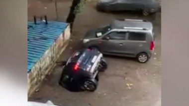 O mașină cade într- groapă formată brusc în parcare