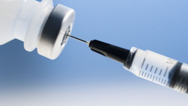 O seringa este umplută cu ser pentru vaccin.