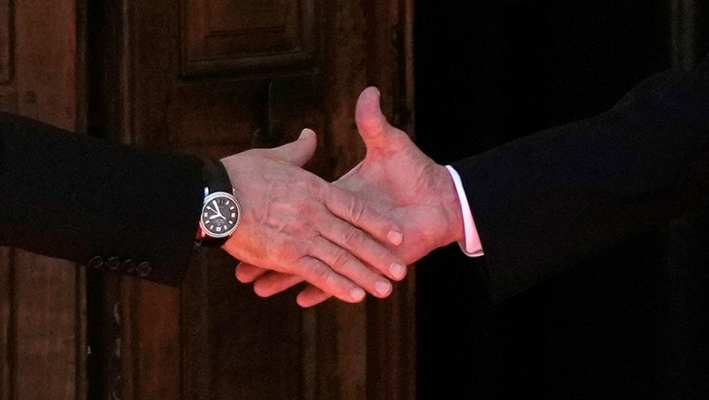mainile lui vladimir Putin si Joe Biden in timp ce dau noroc