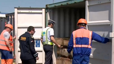 oameni si politie deschid usa unui container cu lemne