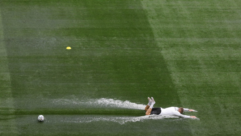 jucator de fotbal aluneca pe terenul imbibat de apa de pe arena nationala