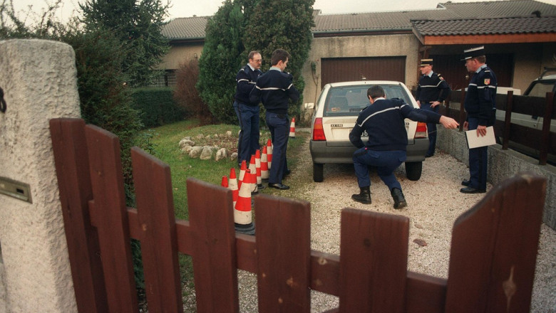 politisti francezi pun sigiliu pe o masina in curtea unei case