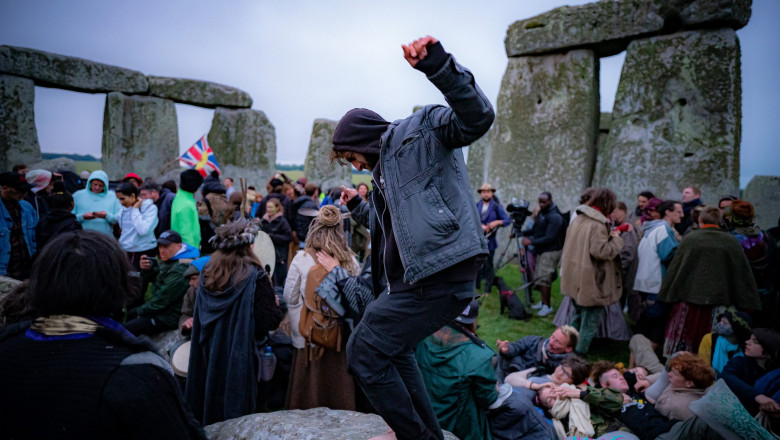 oameni urcati pe pietrele dela stonehenge in ziua de solstitiu