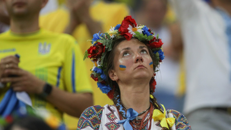 o ucraineanca in port national si cu coroana de flori pe cap priveste in sus dezamagita la meciul Ucraina Austria de pe Arena Nationala