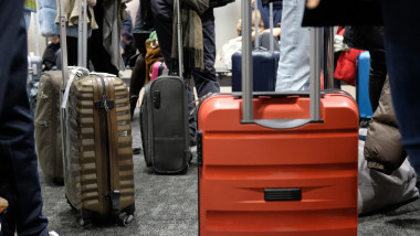 Oameni cu bagaje în aeroport.