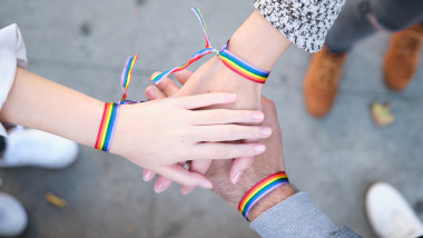 persoanele cu steag LGBT se țin de mână