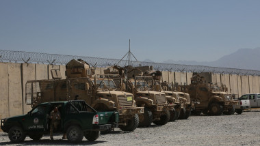 Vehicule militare lângă un gard cu sârmă ghimpată