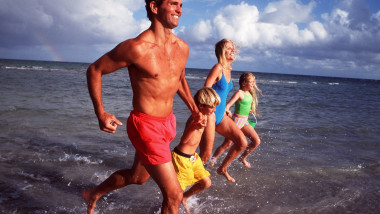 FAMILY - HOLIDAY RUNNING ALONG BEACH - SEA