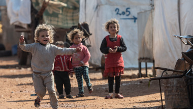 copii aleargă și se joacă într-o tabără de refugiați