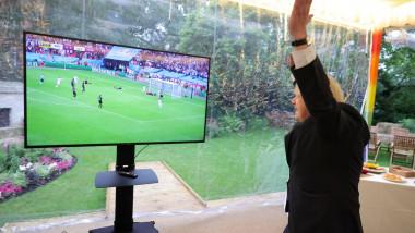 Boris Johnson cu mâinile în aer, uitându-se la meci la tv