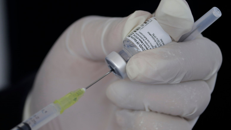 Un cadrul medical umple o seringă cu ser pentru vaccinare.