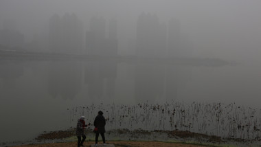 Doi oameni se plimă în orașul Wuhan îngropat de smog