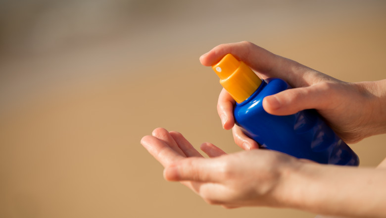 sticla de aplicare spray a lotiunii de plaja pe mana